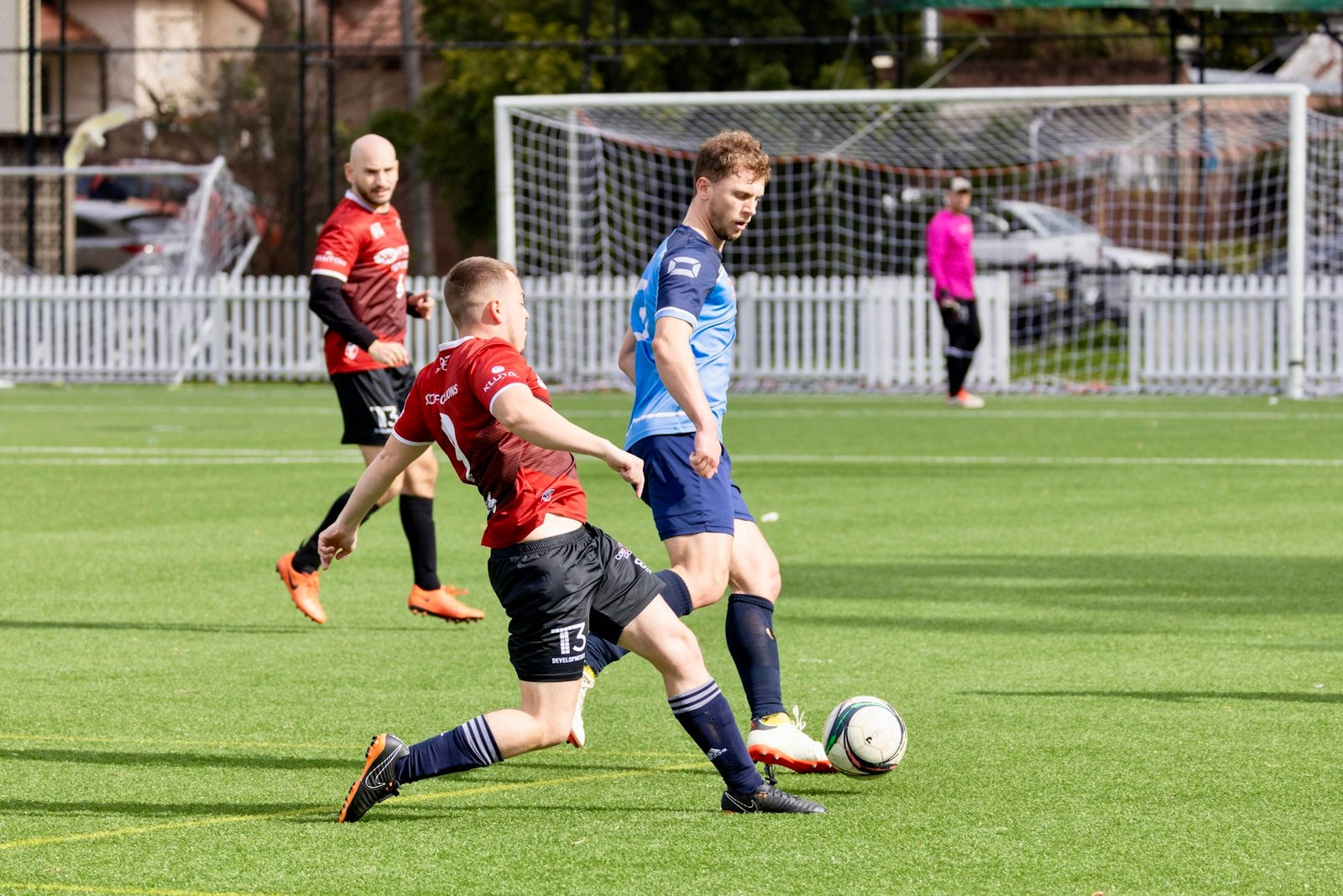 Adult players challenging for possession